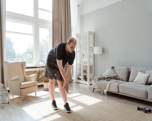 Person doing light stretching in their living room